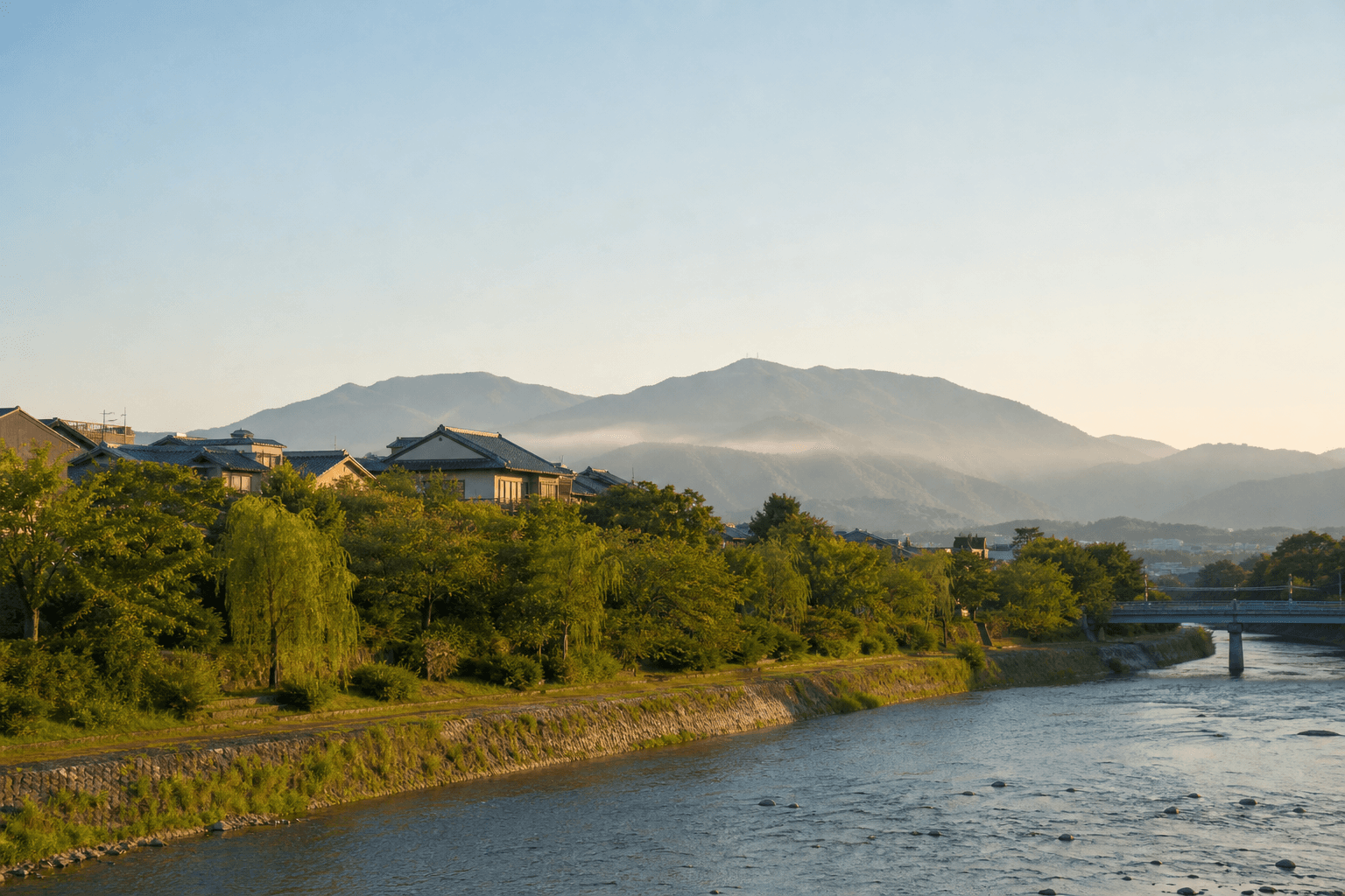 京都を思わせる穏やかな川沿いの風景と遠くの山並み